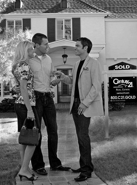 Couple meeting their realtor in outside of a home for sale